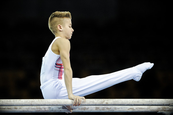 Young gymnast builds up his strength and skills on the parallel bars